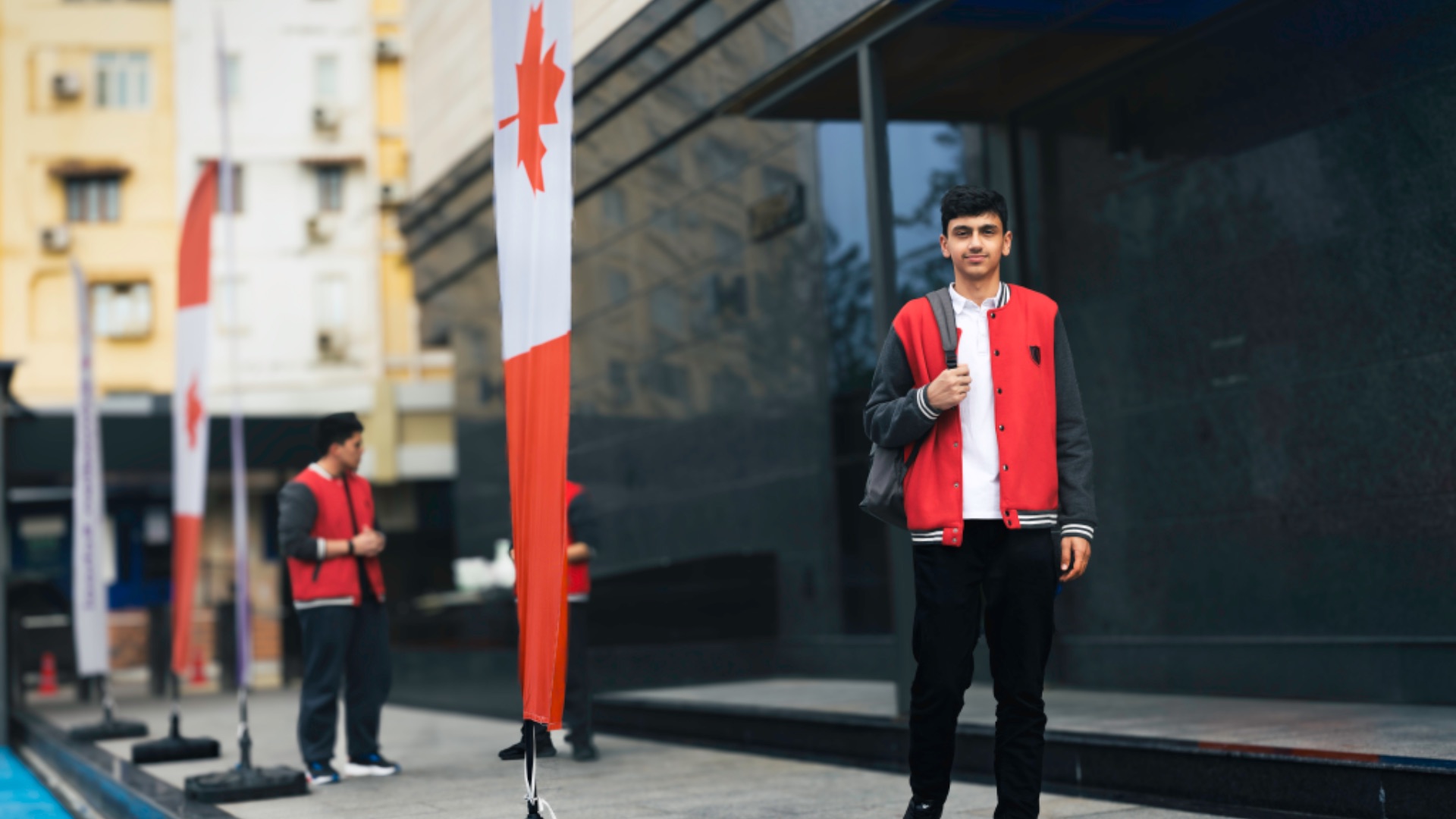 A CST high school student in front of the Canadian flag