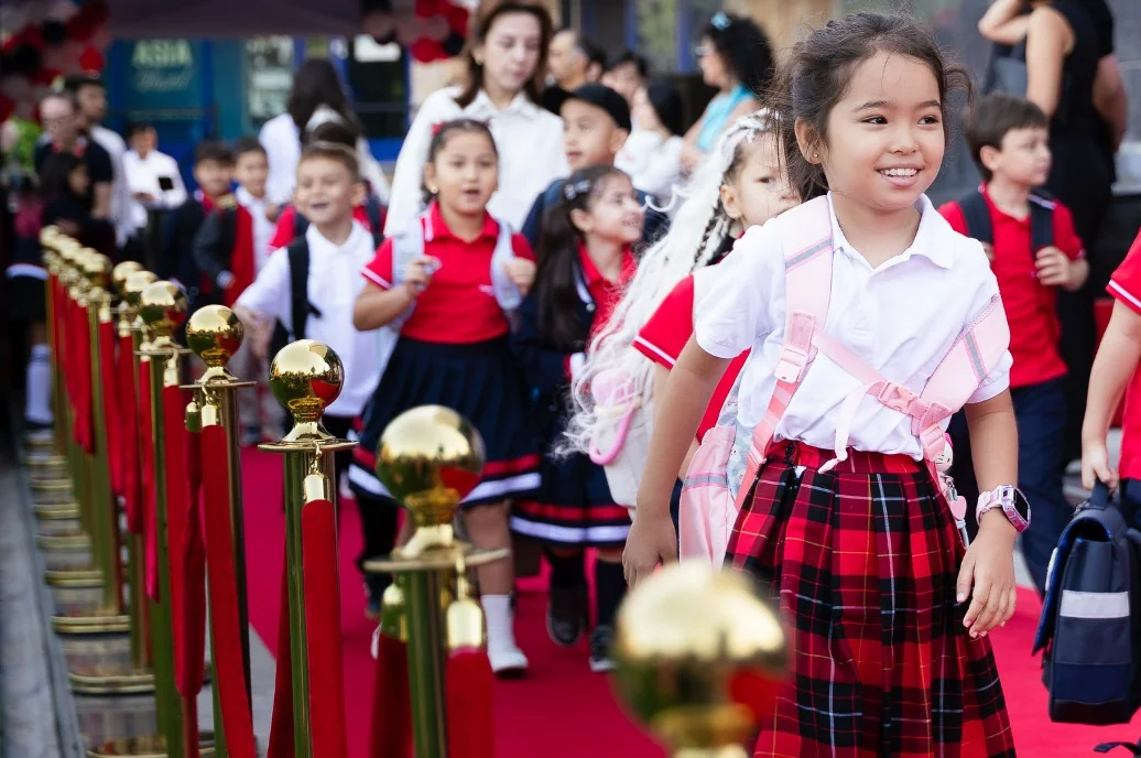 Primary students in CST uniform walking the red carpet on the first day of school