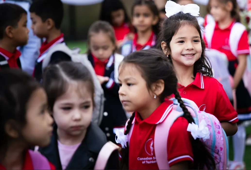 Primary students in CST uniform smiling on the first day of the school year