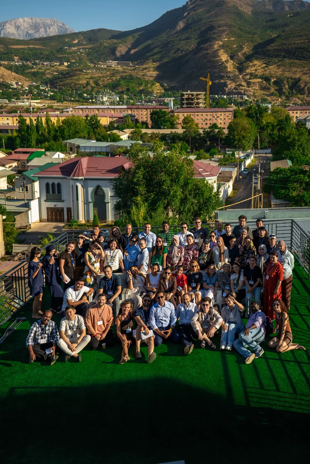 The CST team gathered on a rooftop lawn with mountains behind