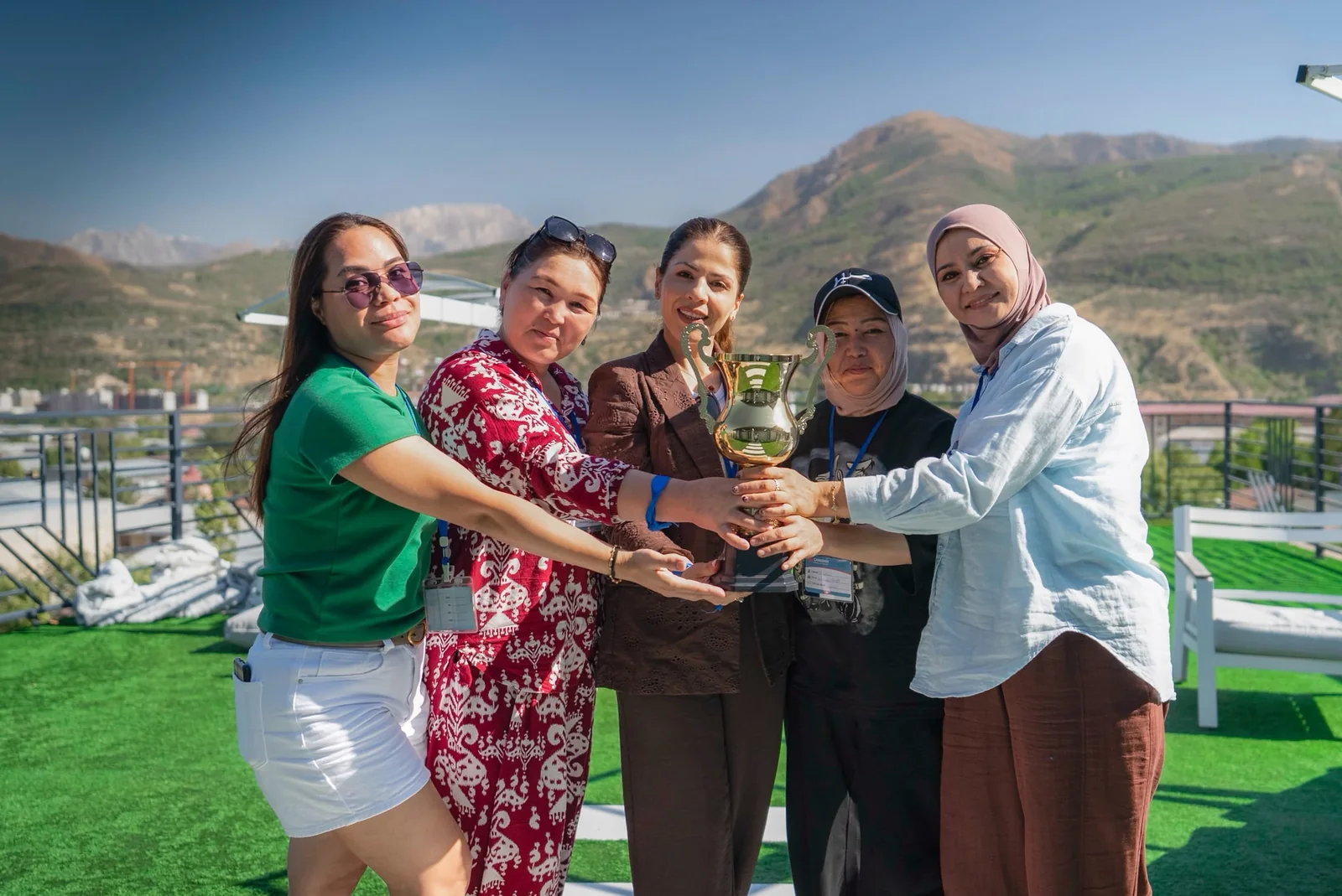 Five colleagues holding the Dacha Cup trophy together