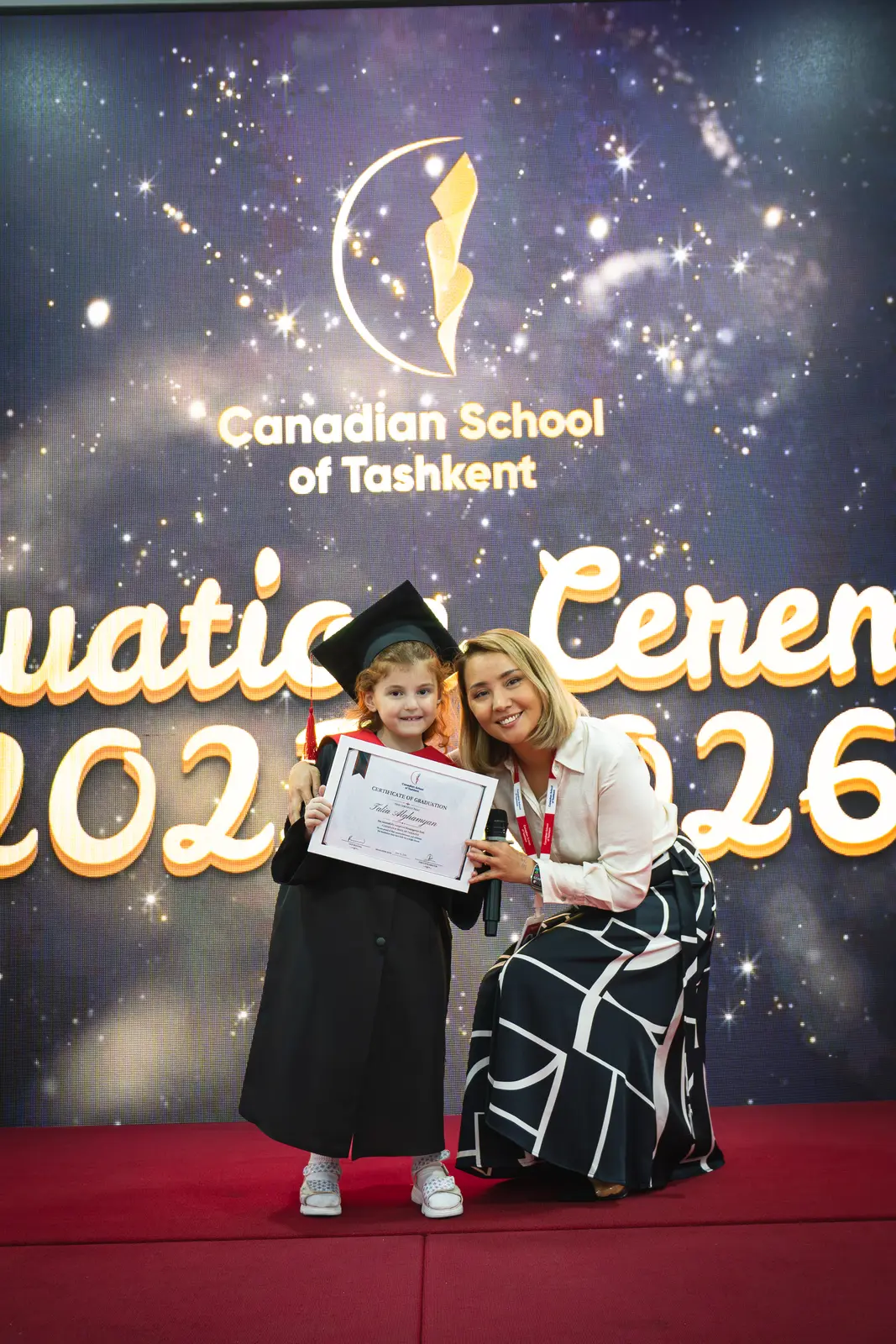 A graduate receiving her certificate from a teacher