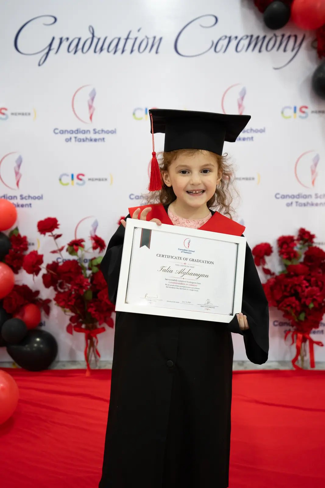 A graduate in cap and gown on the red carpet