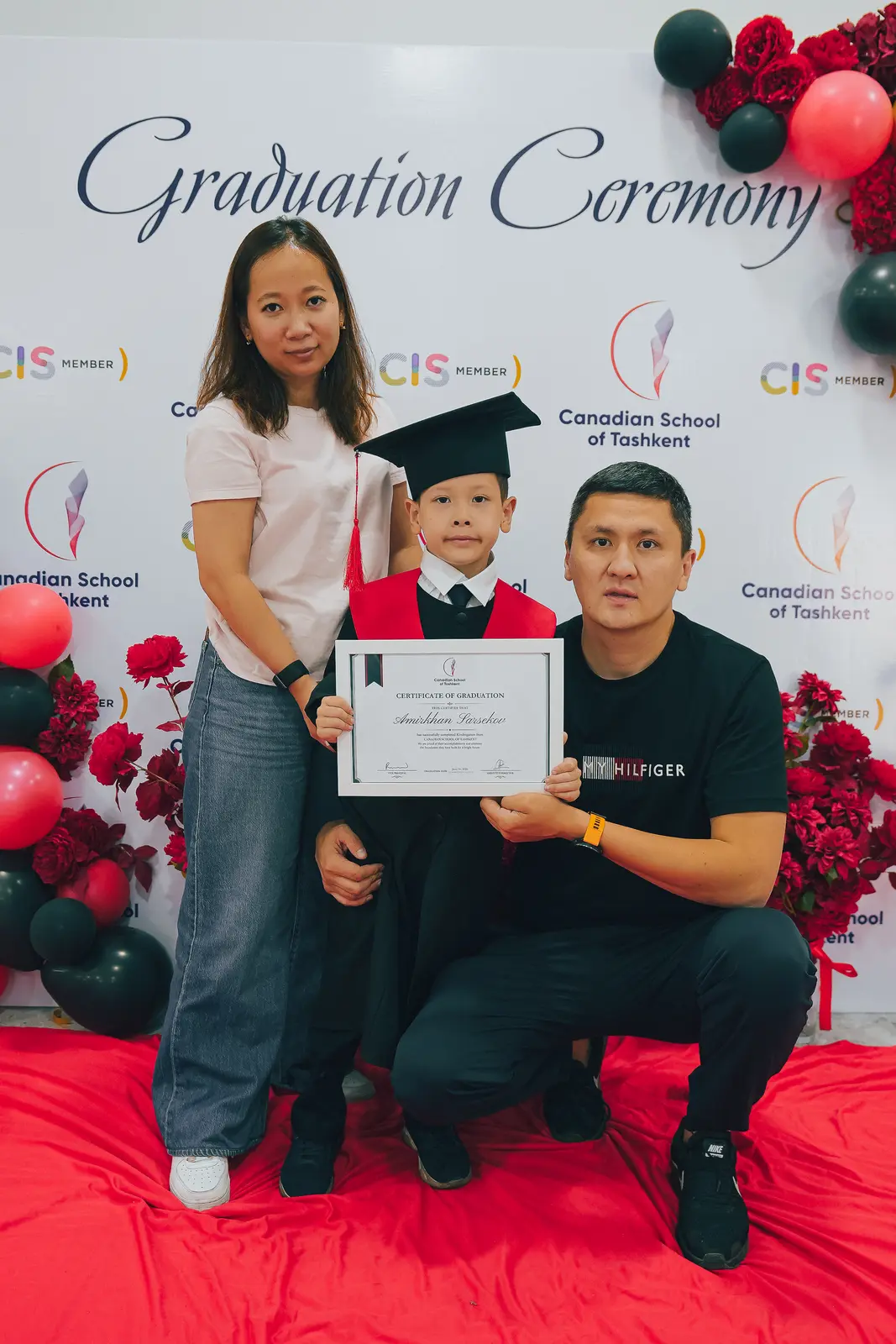 A kindergarten graduate with her parents